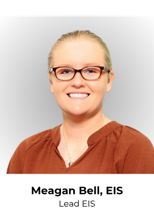 A person with blonde hair, wearing glasses and a brown top, smiles warmly against a light background.